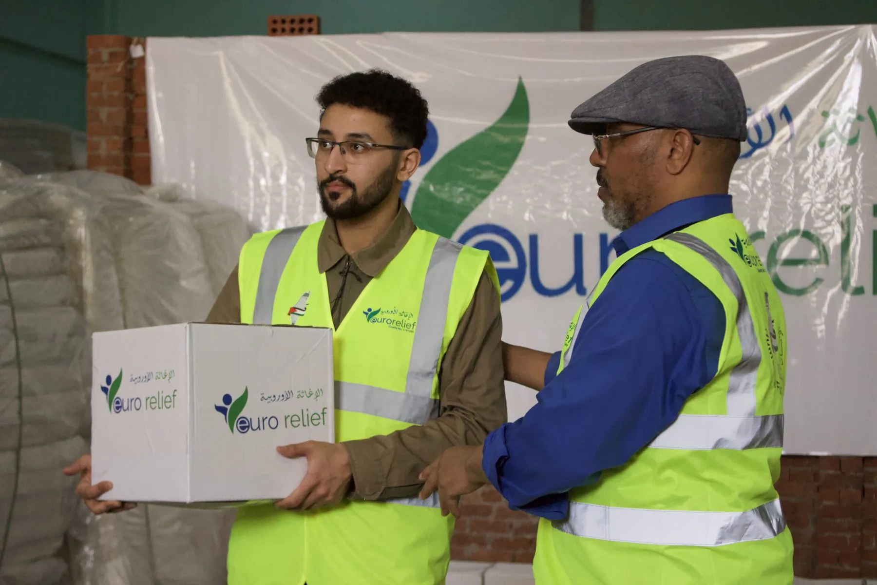Euro Relief volunteers hand over a box of aid
